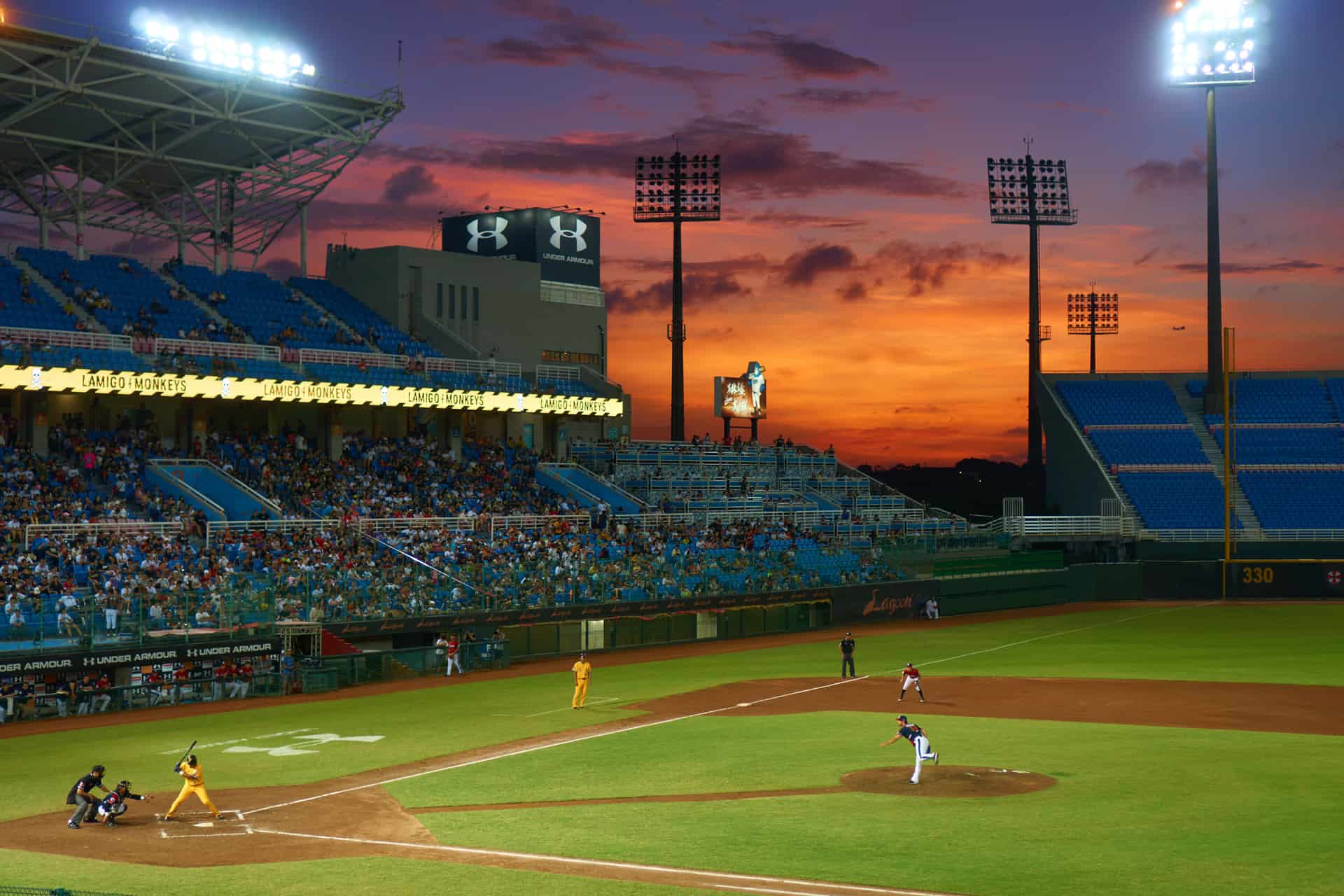 Aerial view of a baseball game in progress under a sunset sky